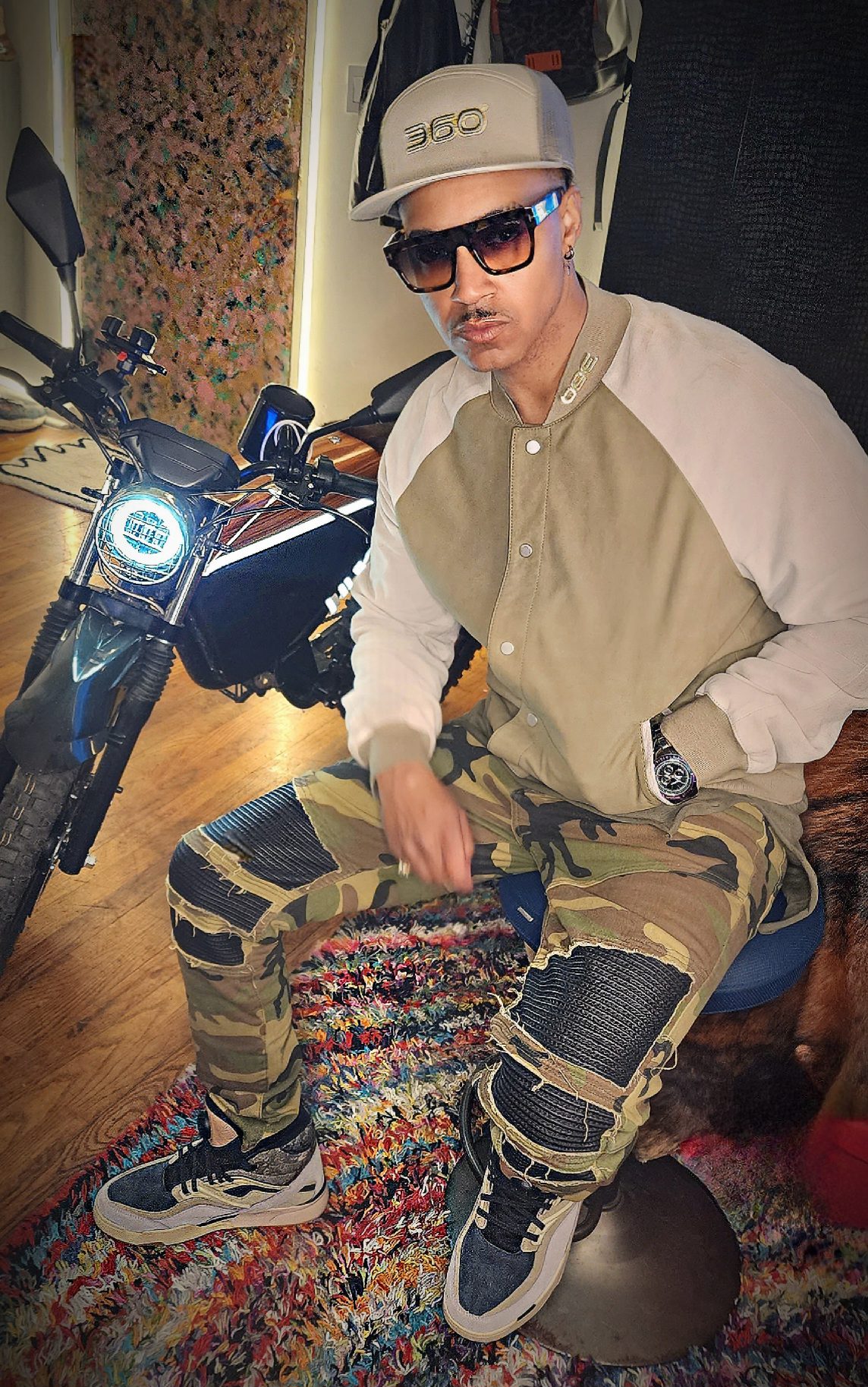 Vaughn Lowery pens article for ONYX RCR Motorbike, wearing Reebok Recreational Activities Sneaker and AllSaints suede varsity Bomber via 360 MAGAZINE.