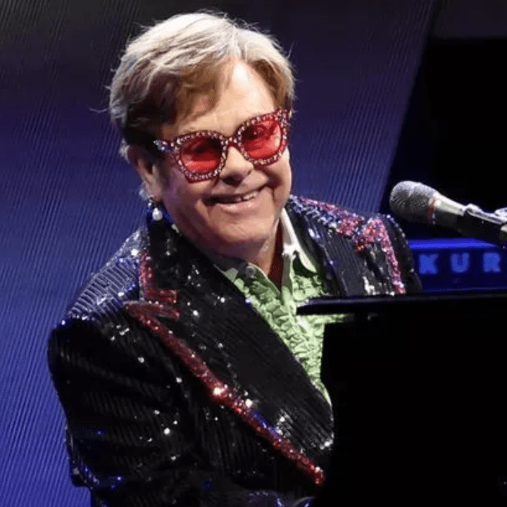 Elton John getting ready to perform and sing in dazzling jacket.