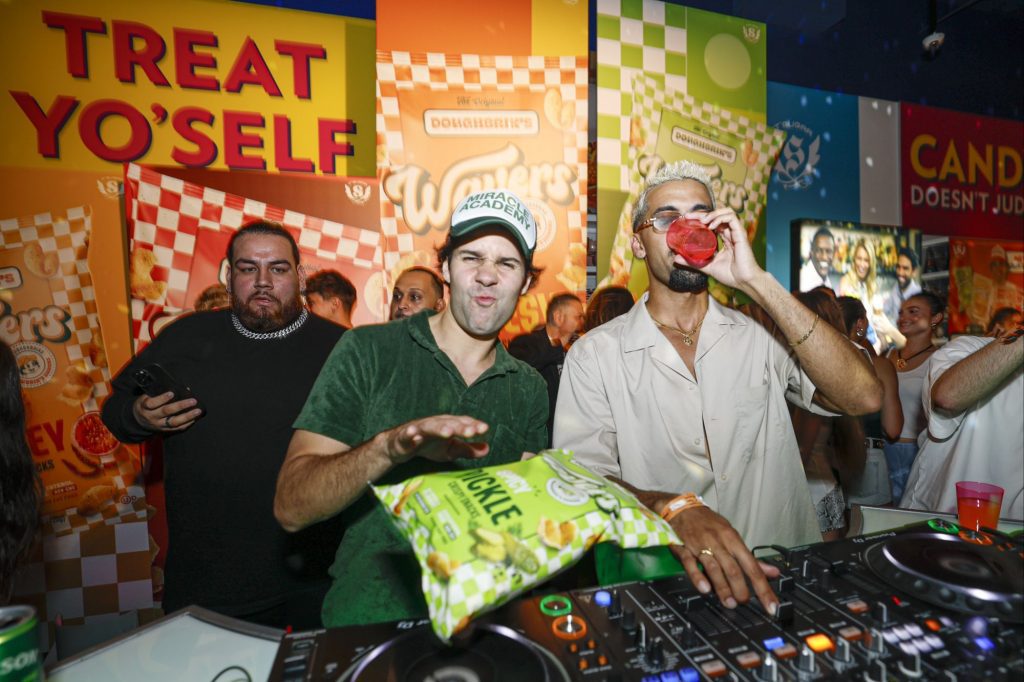 David Dobrik hosts Lollapalooza afterparty in celebration of the nationwide launch of Wavers, his pizza-inspired snack, at IT’SUGAR’s flagship store in Chicago, where he jumped in the DJ booth with DJ Nate Wyatt for an impromptu guest spin via 360 MAGAZINE.