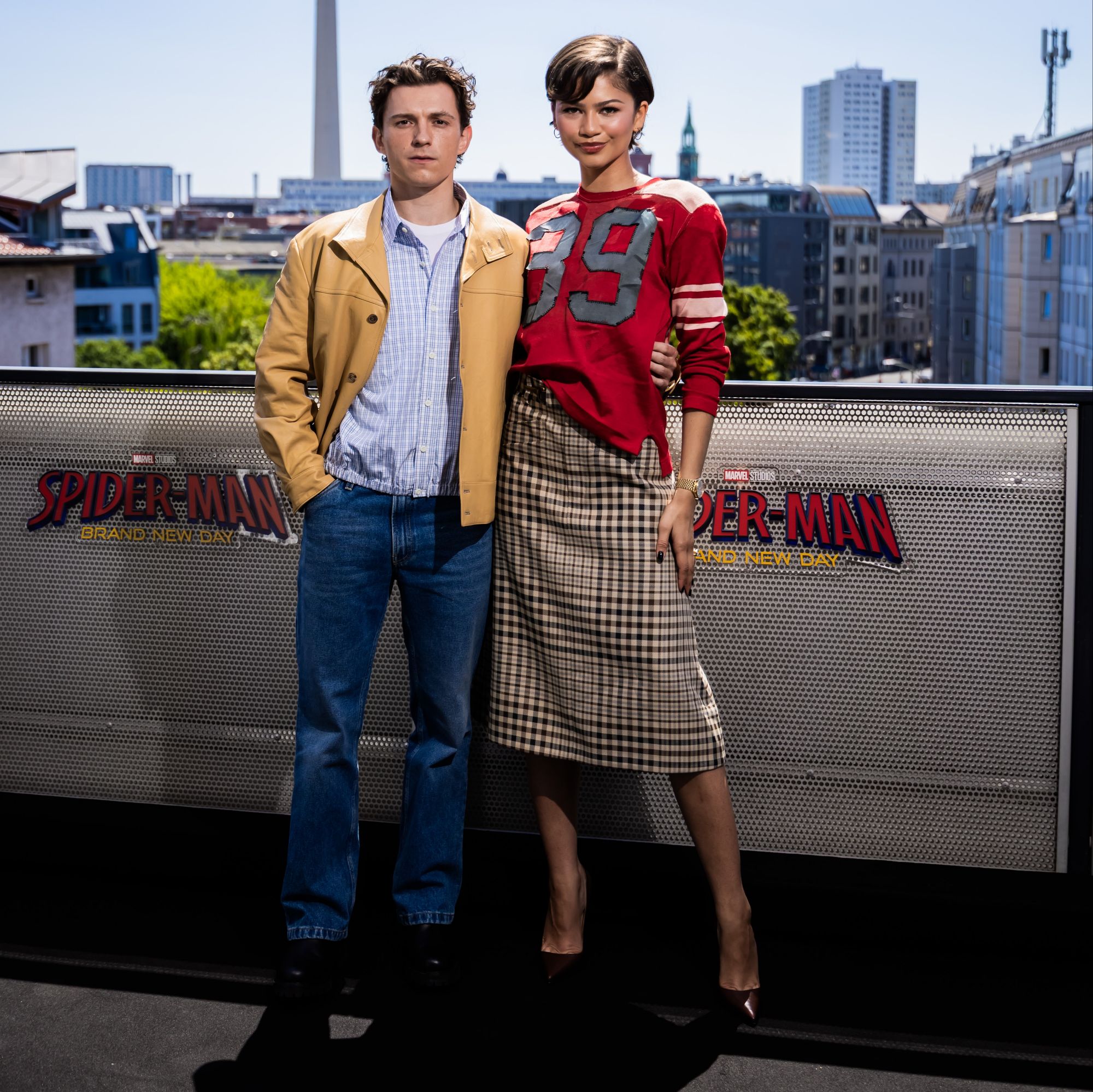 Zendaya wears a Coach Fall 2026 numbered long sleeve tee and a plaid skirt while doing press for Spider-Man: Brand New Day via 360 MAGAZINE.